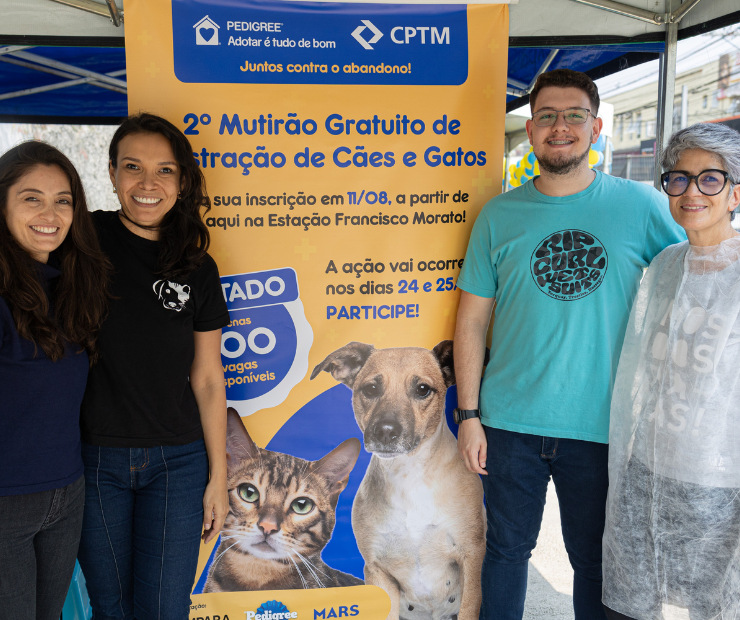 4 pessoas ao lado de um cartaz com informações sobre o 2º mutirão gratuito de castração de cães e gatos