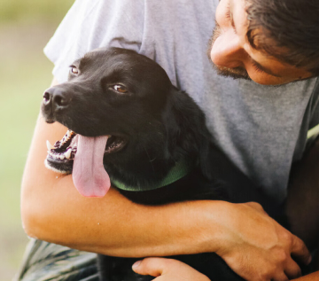 Homem abraçando cachorro