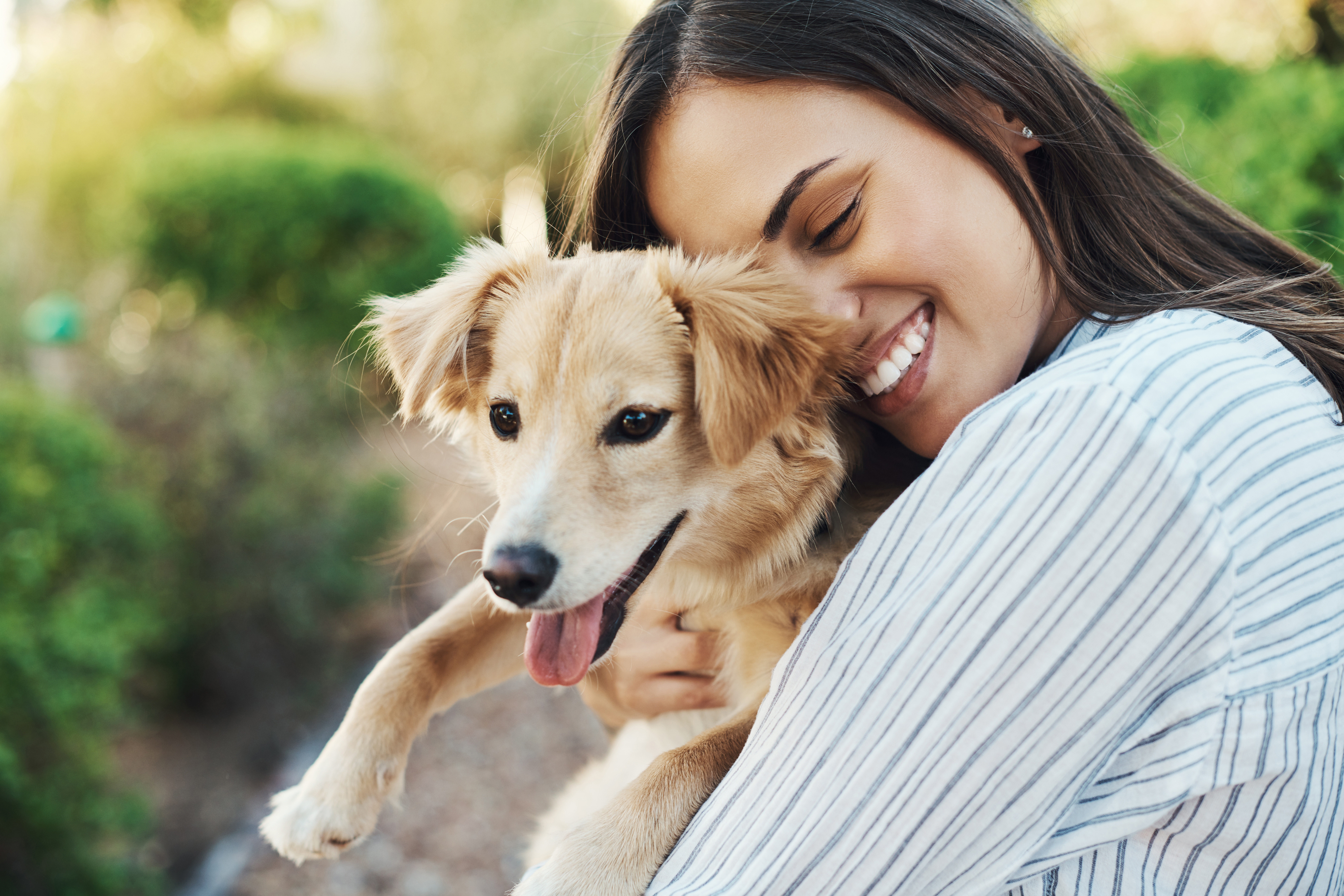 Mulher feliz abraçando cachorro adotado.